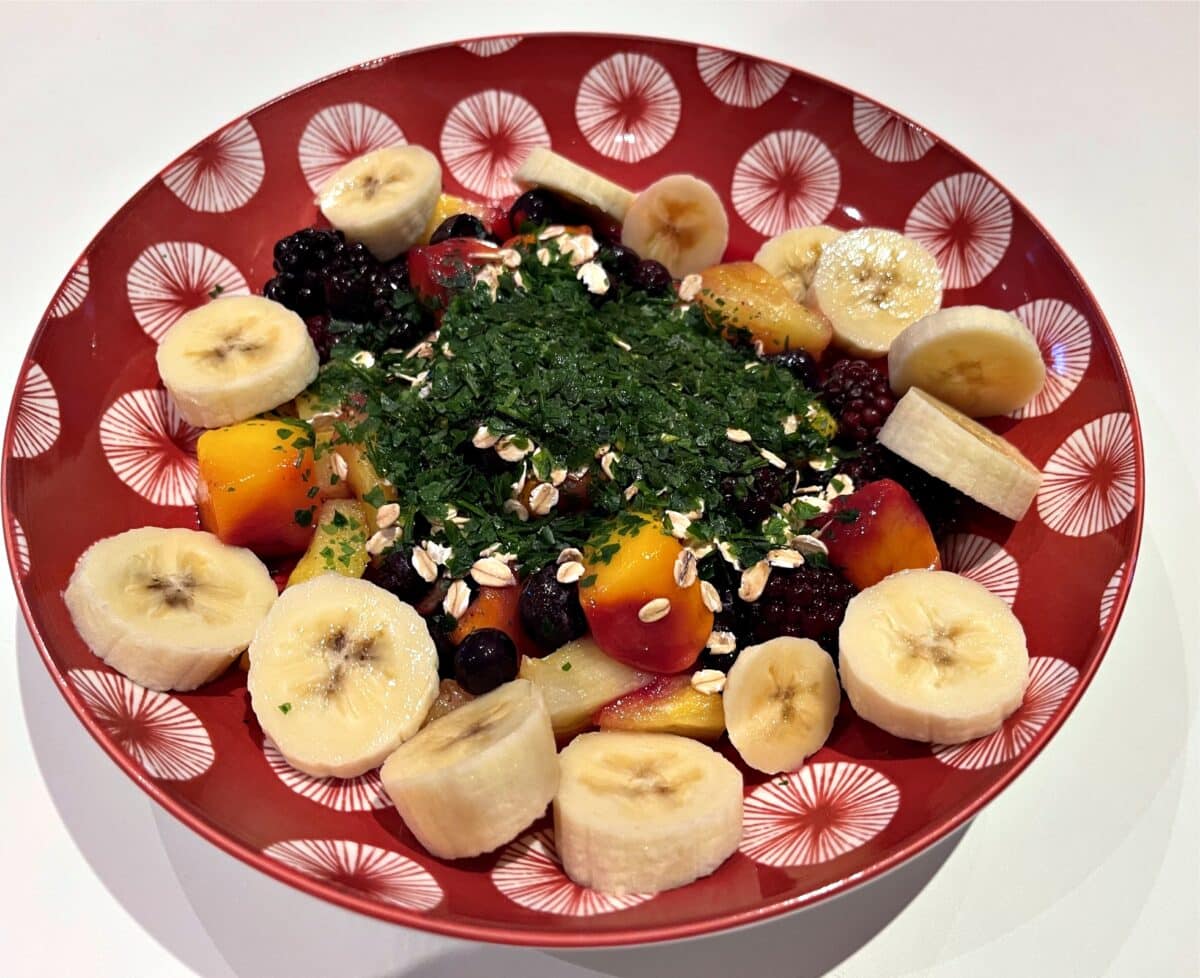 A gentle breakfast: red fruit, banana, sprouted oatmeal, parsley and grated coconut powder for a day full of vitality without intestinal irritation