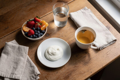 Petit déjeuner équilibré aux fruits frais et yaourt sur une table en bois, lumière douce du matin.